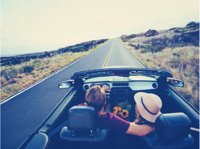 couple driving in convertible car